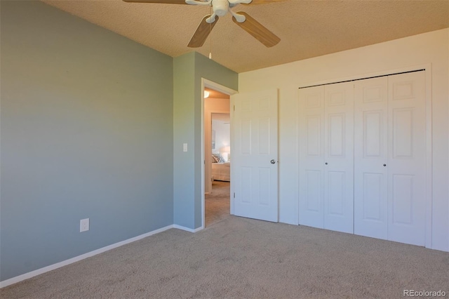 unfurnished bedroom featuring a closet, ceiling fan, light carpet, and a textured ceiling