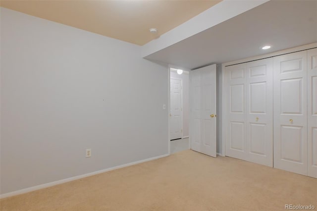 unfurnished bedroom with light colored carpet and a closet