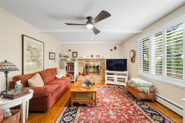 9765 W 77th Dr, Arvada, CO 80005 - living area with a baseboard heating unit, wood finished floors, a ceiling fan, a fireplace, and beam ceiling