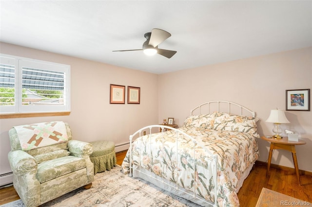 9765 W 77th Dr, Arvada, CO 80005 - bedroom featuring wood finished floors, baseboards, ceiling fan, and baseboard heating