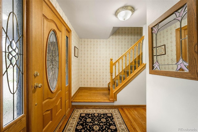 9765 W 77th Dr, Arvada, CO 80005 - entrance foyer featuring wood finished floors, stairway, wallpapered walls, and baseboards