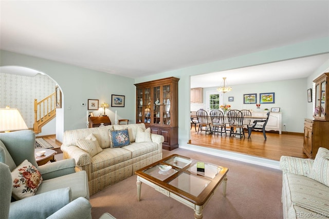 9765 W 77th Dr, Arvada, CO 80005 - living room with a chandelier, wallpapered walls, arched walkways, wood finished floors, and stairway