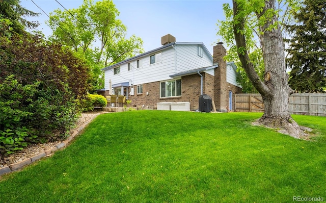 9765 W 77th Dr, Arvada, CO 80005 - back of house featuring brick siding, a chimney, and central AC unit