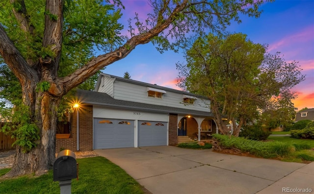 9765 W 77th Dr, Arvada, CO 80005 - view of front of home with brick siding, driveway, and covered porch