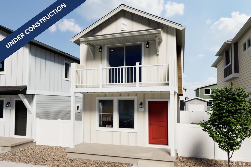 view of front of property featuring a balcony, board and batten siding, and fence