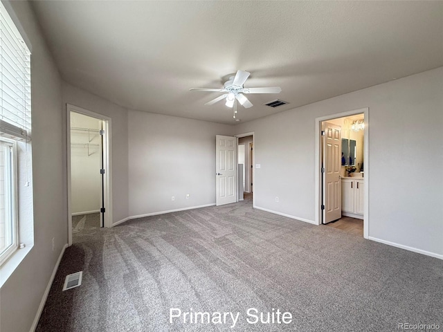 10676 Forester Pl, Longmont, CO 80504 - unfurnished bedroom featuring carpet flooring, baseboards, a walk in closet, and a ceiling fan