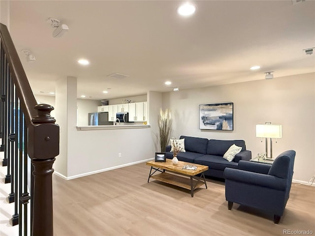 10676 Forester Pl, Longmont, CO 80504 - living room featuring stairs, light wood finished floors, recessed lighting, and baseboards