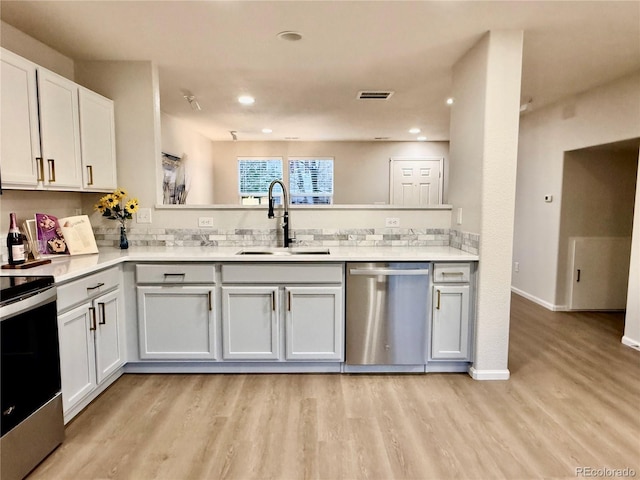 10676 Forester Pl, Longmont, CO 80504 - kitchen featuring appliances with stainless steel finishes, a sink, light wood-style flooring, light countertops, and backsplash