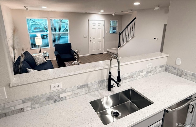 10676 Forester Pl, Longmont, CO 80504 - kitchen featuring a sink, stainless steel dishwasher, recessed lighting, light stone countertops, and baseboards