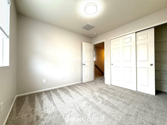 10676 Forester Pl, Longmont, CO 80504 - unfurnished bedroom with carpet flooring, a closet, baseboards, and a textured ceiling