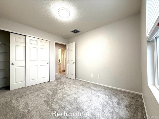 10676 Forester Pl, Longmont, CO 80504 - unfurnished bedroom with carpet floors, a textured ceiling, baseboards, and a closet