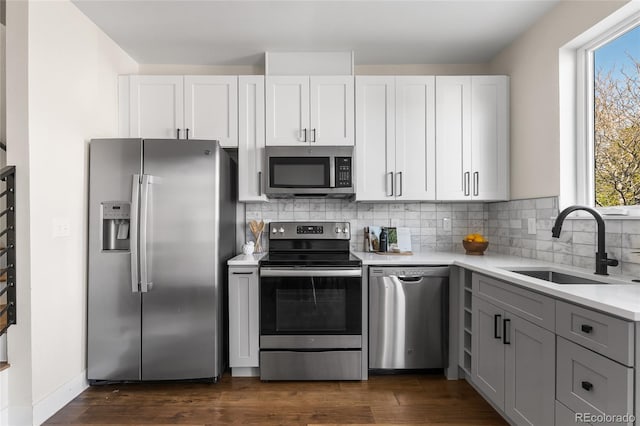1305 Osceola St, Denver, CO 80204 - kitchen featuring appliances with stainless steel finishes, a sink, light countertops, decorative backsplash, and dark wood-style floors