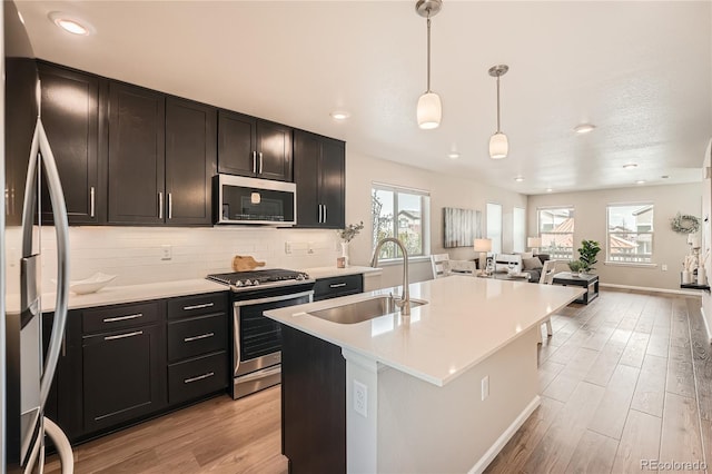 12770 Tamarac St, Thornton, CO 80602 - kitchen with a sink, light wood-style flooring, appliances with stainless steel finishes, and open floor plan