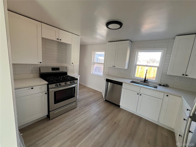 kitchen featuring decorative backsplash, white cabinetry, sink, and stainless steel appliances