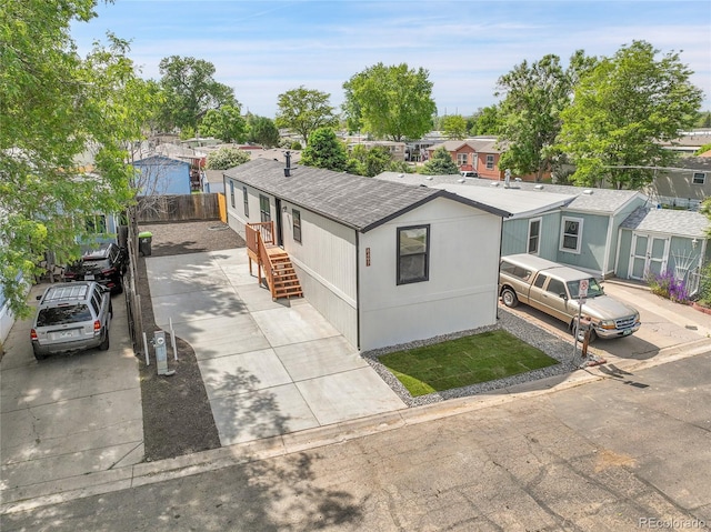 8497 Madison Way, Denver, CO 80229 - manufactured / mobile home featuring driveway, a shingled roof, and a residential view