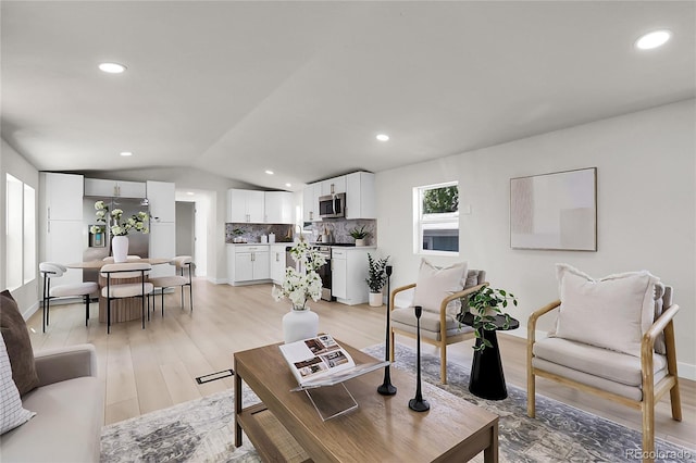 8497 Madison Way, Denver, CO 80229 - living area with vaulted ceiling, light wood-style flooring, and recessed lighting