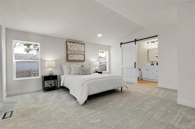 8497 Madison Way, Denver, CO 80229 - bedroom with a barn door, carpet flooring, baseboards, a sink, and vaulted ceiling