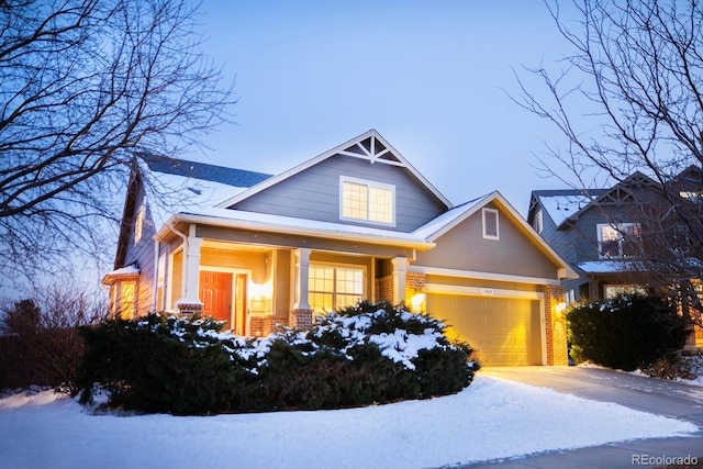 craftsman-style house with a porch, brick siding, driveway, and an attached garage