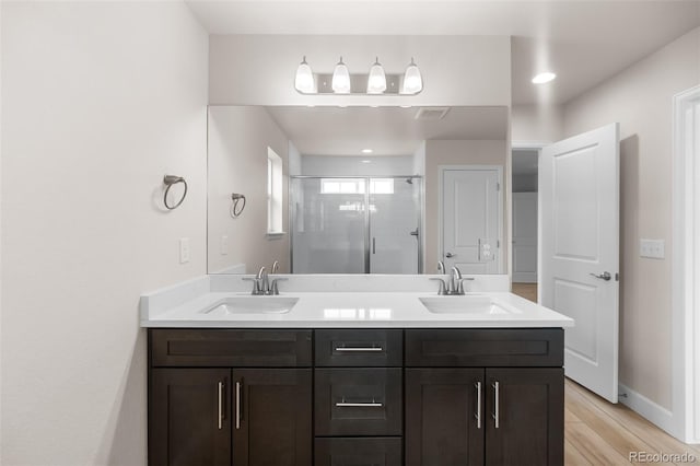 4543 Cholla Trl, Castle Rock, CO 80104 - bathroom featuring a stall shower, double vanity, wood finished floors, and recessed lighting