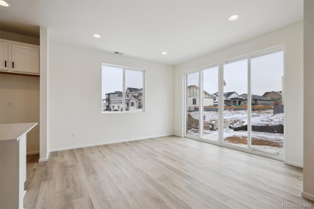 interior space with light wood-style floors, recessed lighting, visible vents, and baseboards