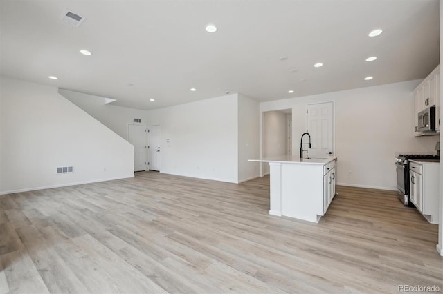 kitchen with white cabinetry, visible vents, appliances with stainless steel finishes, and open floor plan