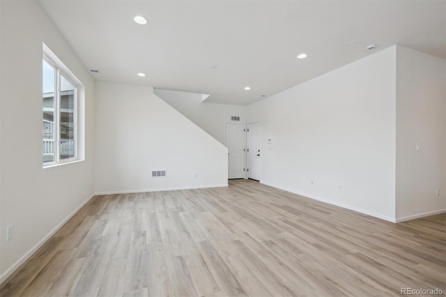 unfurnished living room with light wood finished floors, baseboards, visible vents, and recessed lighting