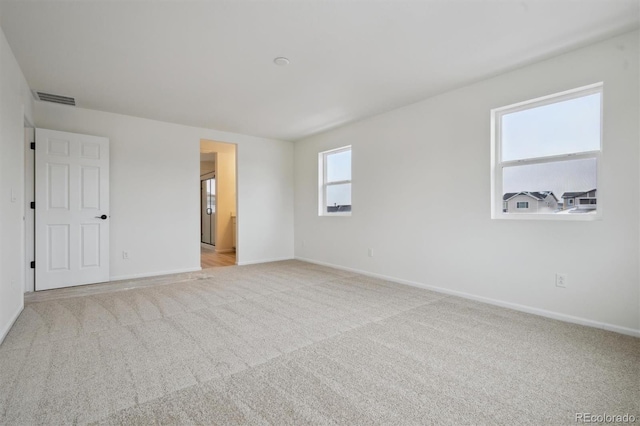 unfurnished bedroom featuring baseboards, visible vents, and light colored carpet