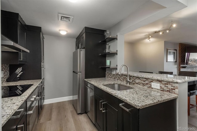 kitchen featuring visible vents, dark cabinets, a sink, appliances with stainless steel finishes, and tasteful backsplash