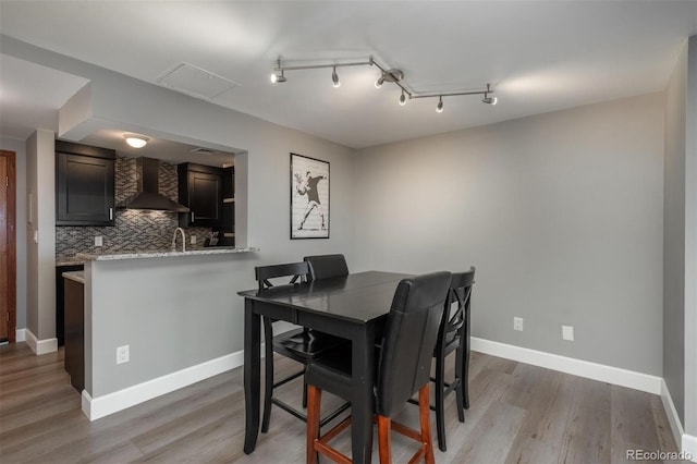 dining room featuring light wood-style flooring and baseboards