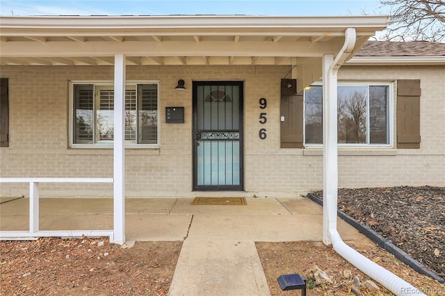 entrance to property featuring brick siding