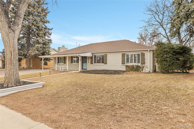 single story home featuring brick siding, a chimney, a front yard, and a shingled roof