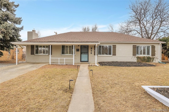 ranch-style home with a shingled roof, covered porch, brick siding, and a chimney