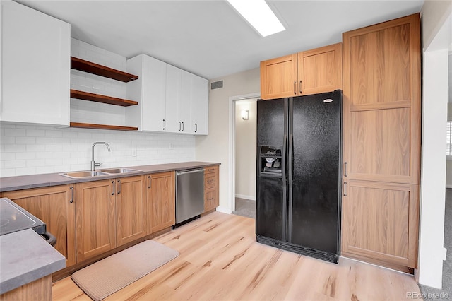 kitchen featuring a sink, stainless steel dishwasher, black fridge, backsplash, and open shelves