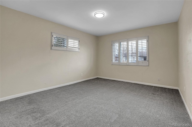 spare room with carpet and baseboards