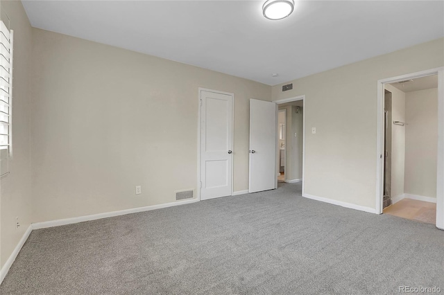 unfurnished bedroom featuring light colored carpet, visible vents, and baseboards