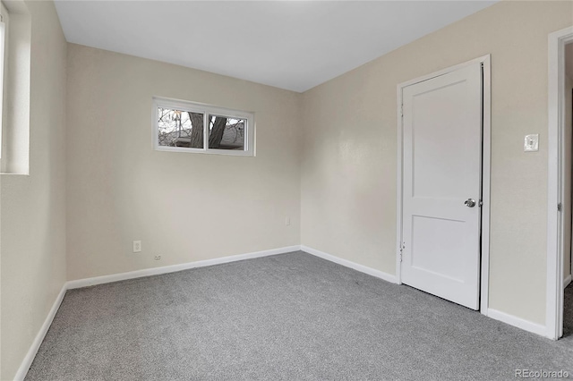 unfurnished room featuring carpet floors and baseboards