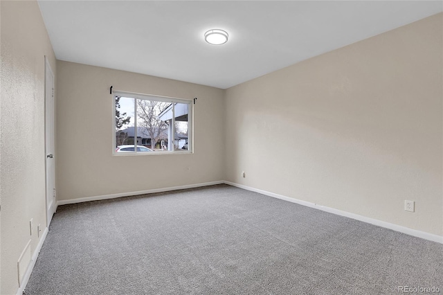 unfurnished room with carpet floors and baseboards