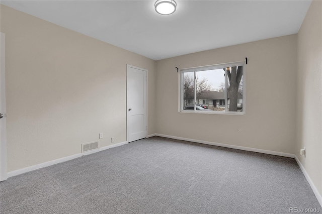 carpeted empty room featuring visible vents and baseboards