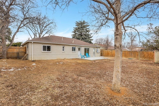 back of property featuring a patio area, a fenced backyard, a shingled roof, and brick siding