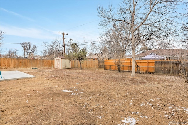 view of yard featuring an outbuilding, a fenced backyard, and a shed