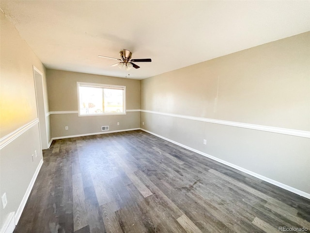 empty room with ceiling fan and dark hardwood / wood-style flooring