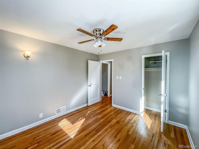 unfurnished bedroom with light hardwood / wood-style flooring, a closet, and ceiling fan