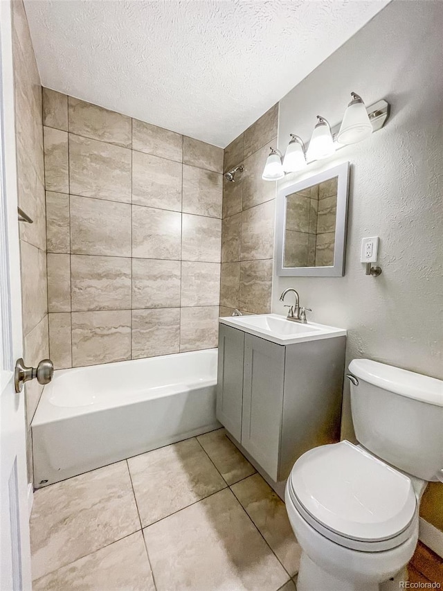 full bathroom with tile patterned floors, toilet, a textured ceiling, vanity, and tiled shower / bath combo