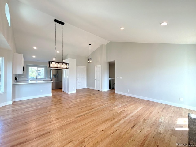 unfurnished living room featuring light hardwood / wood-style flooring and vaulted ceiling