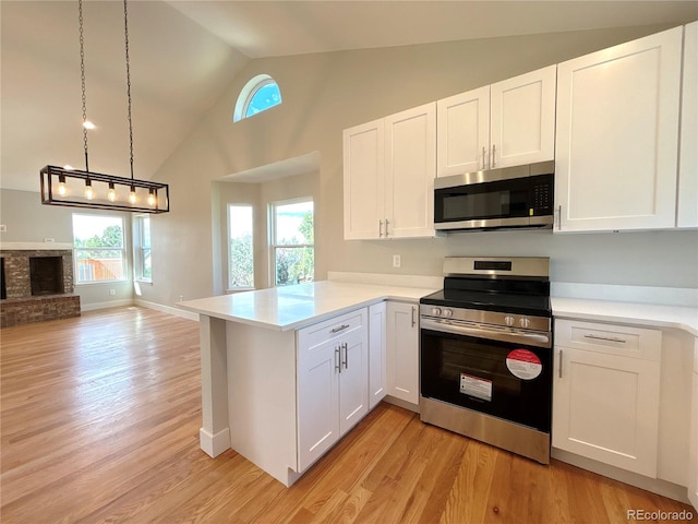 kitchen featuring appliances with stainless steel finishes, kitchen peninsula, and white cabinets