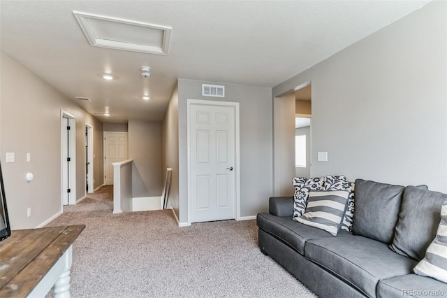 living area featuring attic access, baseboards, visible vents, and carpet flooring