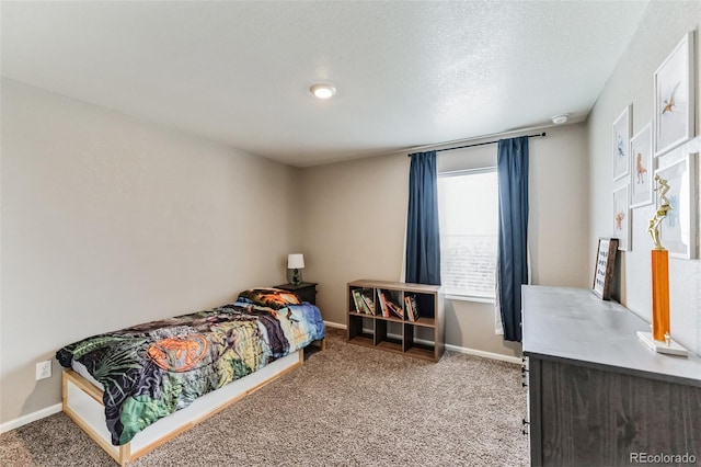 carpeted bedroom featuring a textured ceiling and baseboards