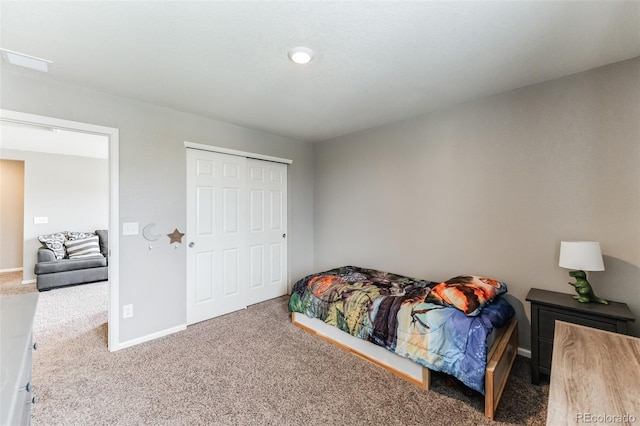 carpeted bedroom featuring a closet and baseboards