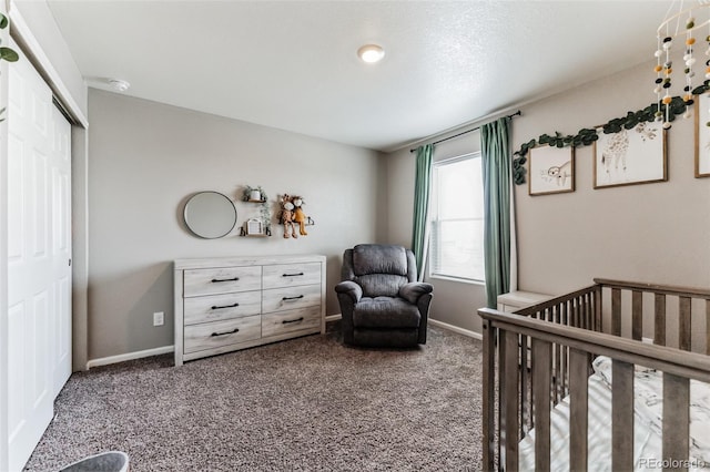 bedroom with carpet, a closet, a nursery area, and baseboards