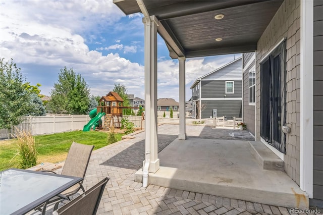 view of patio / terrace with outdoor dining space, a playground, and a fenced backyard